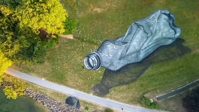 Художник нарисовал гигантскую пластиковую бутылку в швейцарском парке в знак протеста
